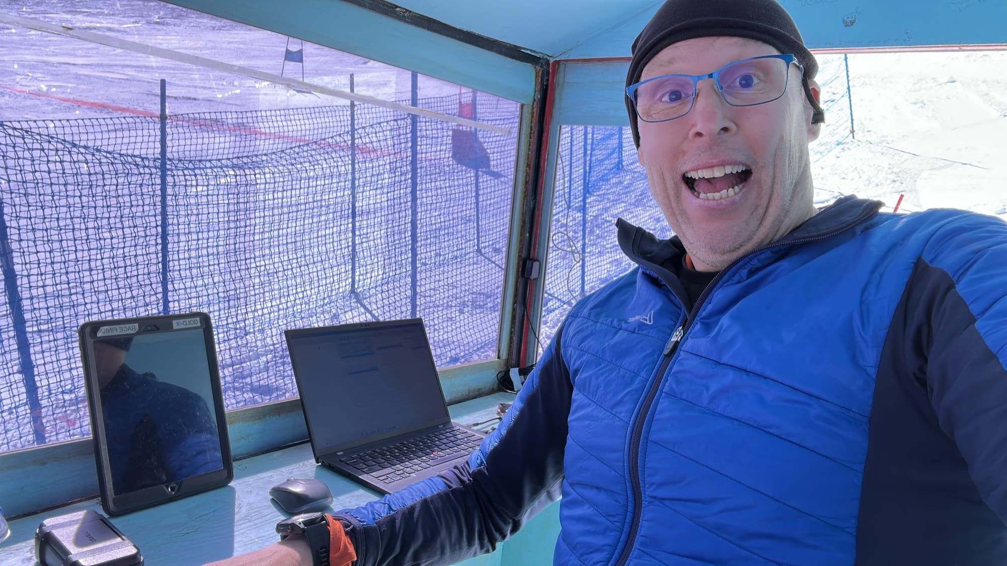 Arno in the timing hut at the finish, laptop and iPad on the desk